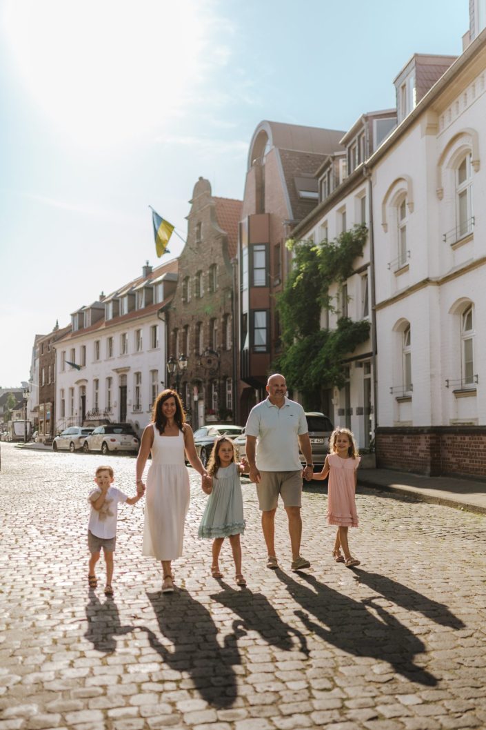 A family of five is walking down Kaiserswerther Markt in Düsseldorf in the sunshine